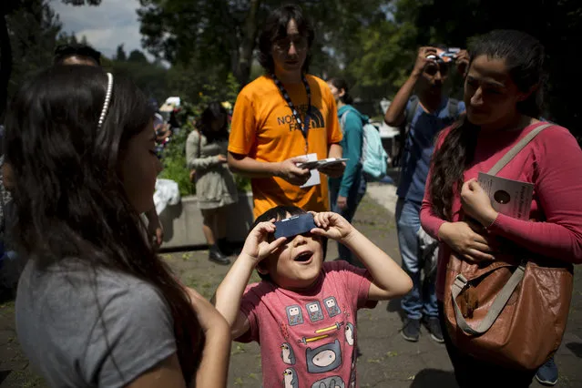 A boy reacts as he views a partial solar eclipse through a filter at the Astronomy Institute on the campus of the National Autonomous University of Mexico, in Mexico City, Monday, August 21, 2017. (Photo by Rebecca Blackwell/AP Photo)