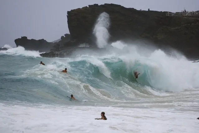 Bodysurfers and boogie boarders catch waves at Sandy beach on the east side of Oahu as Tropical Storm Iselle passes through the Hawaiian islands, in Honolulu, Hawaii, August 8, 2014. The center of Tropical Storm Iselle made landfall on Hawaii's Big Island on Friday, bringing strong winds and heavy rain, knocking down trees and causing power outages ahead of a more powerful storm gathering strength behind it. (Photo by Hugh Gentry/Reuters)