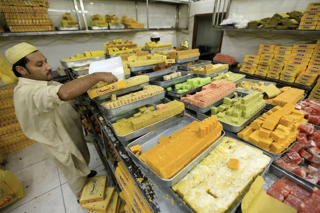 A Pakistani vendor arranges sweets for sale ahead of Eid al-Fitr, the festival marking the end of holy fasting month of Ramadan, in Peshawar, Pakistan, 24 June 2017. Muslims around the world celebrate the holy month of Ramadan by praying during the night time and abstaining from eating, drinking, and sexual acts daily between sunrise and sunset. Ramadan is the ninth month in the Islamic calendar and it is believed that the Koran's first verse was revealed during its last 10 nights. (Photo by Arshad Arbab/EPA)