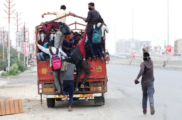 A migrant worker runs behind a truck as others try to board it to return to their villages after India ordered a 21-day nationwide lockdown to limit the spreading of coronavirus disease (COVID-19), in Ghaziabad, on the outskirts of New Delhi, March 26, 2020. (Photo by Adnan Abidi/Reuters)