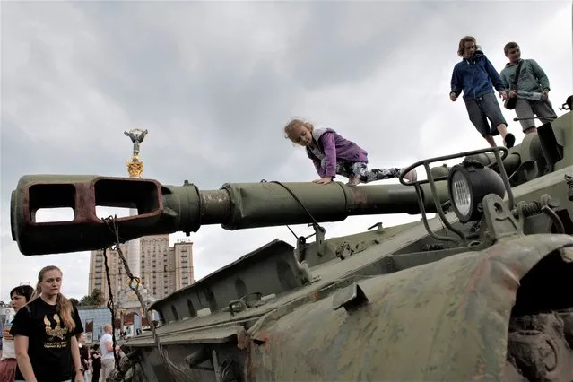 Ukrainians visit an avenue where destroyed Russian military vehicles have been displayed in Kyiv, Ukraine, Saturday, August 20, 2022. (Photo by Andrew Kravchenko/AP Photo)