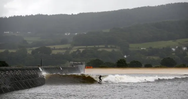 Surfers surf at Surf Snowdonia in Conwy, North Wales, September 3, 2015. (Photo by Andrew Yates/Reuters)