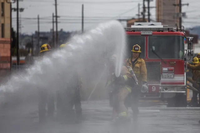 Cameron Richards, a probationary firefighter holds a water hose in a morning training session of the LAFD Station No9 team at Skid Row on April 12, 2020 in downtown Los Angeles, California. One of the busiest fire station in the country, LA Fire Station 9 is on the front lines of California's homeless crisis e Coronavirus pandemic. (Photo by Apu Gomes/AFP Photo)