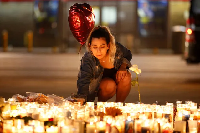 A woman lights candles at a vigil on the Las Vegas strip following a mass shooting at the Route 91 Harvest Country Music Festival in Las Vegas, Nevada, U.S., October 2, 2017. Picture taken October 2, 2017. (Photo by Chris Wattie/Reuters)