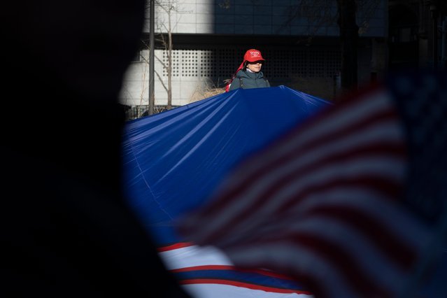 A President-elect Donald Trump supporter holds a segment of a giant flag as Trump appears remotely before a judge for a sentencing hearing at Manhattan Criminal Courthouse in New York City on Friday, January 10, 2025. (Photo by USA Today)