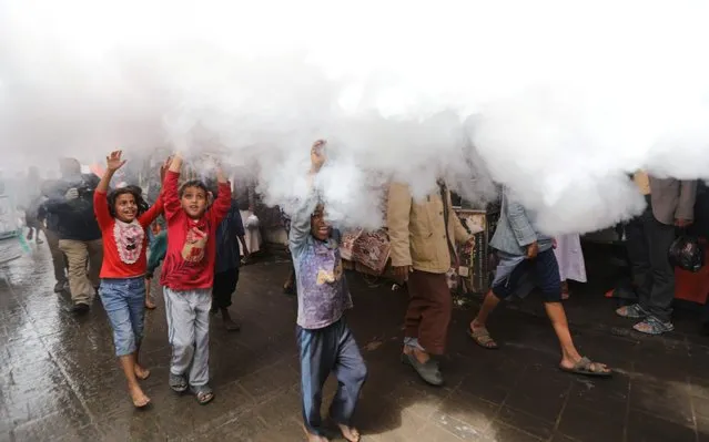 Children react as health workers fumigate a market amid concerns of the spread of the coronavirus disease (COVID-19), in Sanaa, Yemen on April 30, 2020. (Photo by Khaled Abdullah/Reuters)