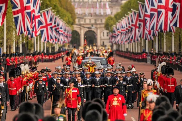 The coffin of Queen Elizabeth II is pulled past Buckingham Palace following her funeral service in Westminster Abbey in central London, Monday, September 19, 2022. The Queen, who died aged 96 on Sept. 8, will be buried at Windsor alongside her late husband, Prince Philip, who died last year. (Photo by Vadim Ghirda/AP Photo/Pool)
