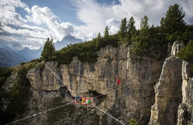 A picture made available on 17 September 2014 shows extreme athletes rest in a hammock on a webbing stretched between rocks during the International Highline Meeting in Monte Piana, near Misurina, in the northern Italian Alps, Italy, 07 September 2014. (Photo by Balazs Mohai/EPA)