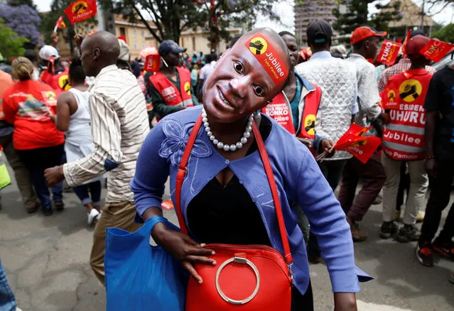 A supporter of Kenya's President Uhuru Kenyatta wears his mask before a Jubilee Party campaign caravan rally in Nairobi, Kenya October 23, 2017. (Photo by Baz Ratner/Reuters)