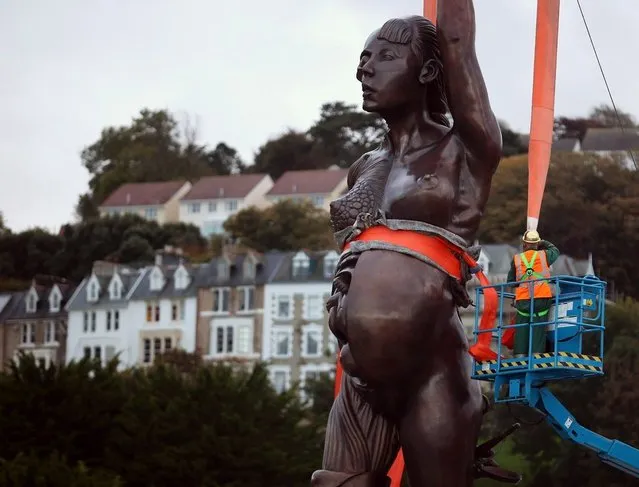 Contractors move Damien Hirst's bronze sculpture of a pregnant woman into position on October 16, 2012 in Ilfracombe, England. The bronze-clad, sword-wielding 65ft (20m) statue, named Verity, has been controversially given to the seaside town by the artist, on a 20-year loan and was erected by crane on the pier.  (Photo by Matt Cardy)