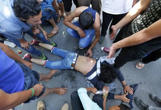 A wounded man lies on the ground after clashes between Syrian and Afghan migrants at the train station in Beli Manastir, Croatia September 18, 2015. (Photo by Laszlo Balogh/Reuters)