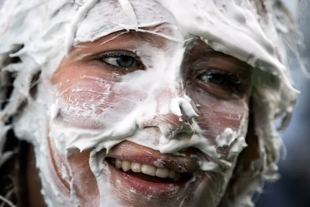 A first year student of the University of St Andrews, takes part in the annual “Raisin Monday Shaving Foam Fight” at the Lower College Lawn, in St Andrews, eastern Scotland, on October 17 2022. The Raisin Monday Costumed Foam Fight is the culmination of a week of mentoring to welcome first year students into the “academic families” as they start their studies at the University of St Andrews. (Photo by Andy Buchanan/AFP Photo)