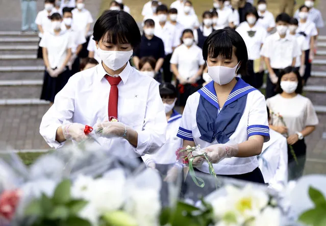 High school students offer flowers for the victims of U.S. atomic bombing in front of a monument at the Atomic Bomb Hypocenter Park in Nagasaki, southern Japan, Sunday, August 9, 2020. Nagasaki marked the 75th anniversary of the atomic bombing on Sunday. (Photo by Kyodo News via AP Photo)