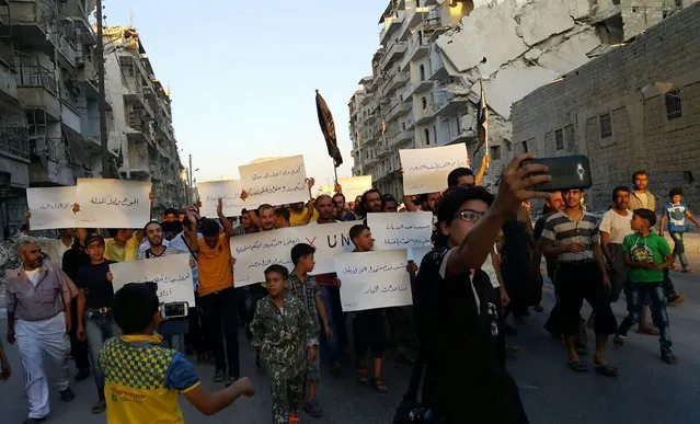 Activists in Syria’s besieged Aleppo protest against the United Nations for what they say is its failure to lift the siege off their rebel-held area, Tuesday, September 13, 2016.  Dozens of protesters marched in al-Shaar neighborhood heading toward the Castello road, the area from which aid is expected to be delivered. “Hunger better than humiliation,” one banner read. “X the UN”, another read. (Photo by Modar Shekho via AP Photo)