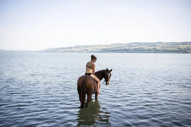A woman rides a horse in the “Rossbadi” in Neuenkirch, Canton Lucerne on August 10, 2020. (Photo by Urs Flueeler/Keystone)