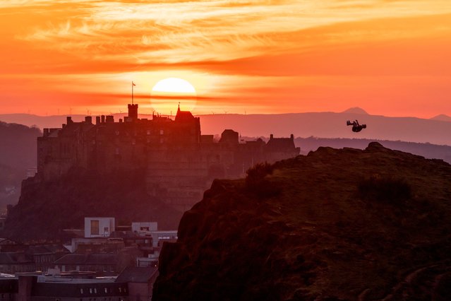 A man observes the sunset on April 10, 2025 over a silhouetted Edinburgh Castle as seen from the summit of Arthur's Seat, Edinburgh, Scotland. (Photo by Tom Duffin/Solent News & Photo Agency)