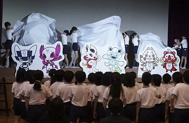 Pupils unveil the shortlisted three mascot design sets which each contain one mascot for the Tokyo 2020 Olympic Games and one for the Paralympic Games at an elementary school in Tokyo Thursday, December 7, 2017. (Photo by Eugene Hoshiko/AP Photo)
