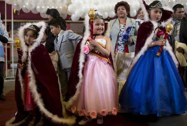 Vanesa Huanca, left, Shanik Vera, center, and Claudia Martinez wear capes and hold staffs as they pose for photos after being crowned “Spring Queens” at their Abel Iturralde public school in El Alto, Bolivia, Wednesday, September 21, 2016. The pre-K, kindergarten and primary school students were chosen by their teachers on Bolivia's annual Student Day, which coincides with the start of the Spring season. (Photo by Juan Karita/AP Photo)