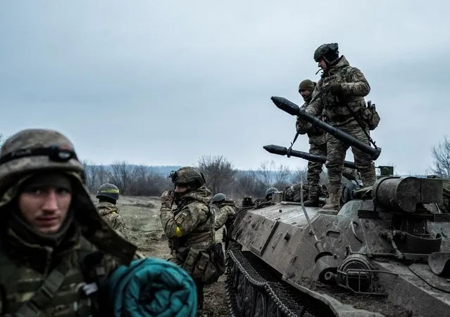 Servicemen of the Carpathian Sich Battalion are seen near an Armoured Personnel Carrier (APC) on a frontline, as Russia's attack on Ukraine continues, near the town of Lyman, Donetsk region, Ukraine on December 8, 2022. (Photo by Viacheslav Ratynskyi/Reuters)