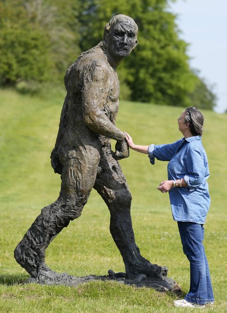 Rachel Holland, ops director of the Chalke History festival, looks at one of a group of eight-foot tall sculptures by Laurence Edwards called “Walking Men”, which have been installed at Broad Chalke, near Salisbury, Wiltshire, UK on Friday, June 13, 2025, ahead of the Chalke History festival which begins on June 23. (Photo by Andrew Matthews/PA Images via Getty Images)