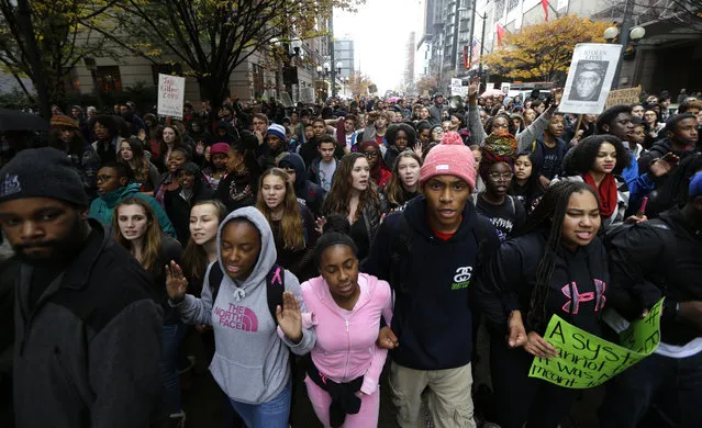 Protesters march in downtown Seattle, Tuesday, November 25, 2014, to demonstrate against a grand jury's decision not to indict a white Ferguson, Missouri, police officer who killed a black 18-year-old. The peaceful march was a mix of students who walked out of schools and a coalition of clergy members. (Photo by Ted S. Warren/AP Photo)