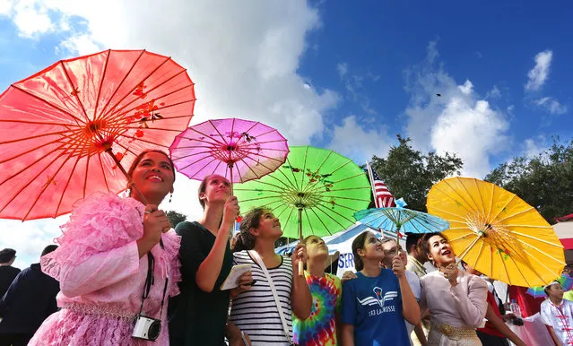 Paweena Jonted, left, and Suparat Pumyu, far right, both representing their native country of Thailand, pose with students from Coleman Middle School in Tampa, Fla. Thursday, October 29, 2015. (Photo by Scott Keeler/The Tampa Bay Times via AP Photo)