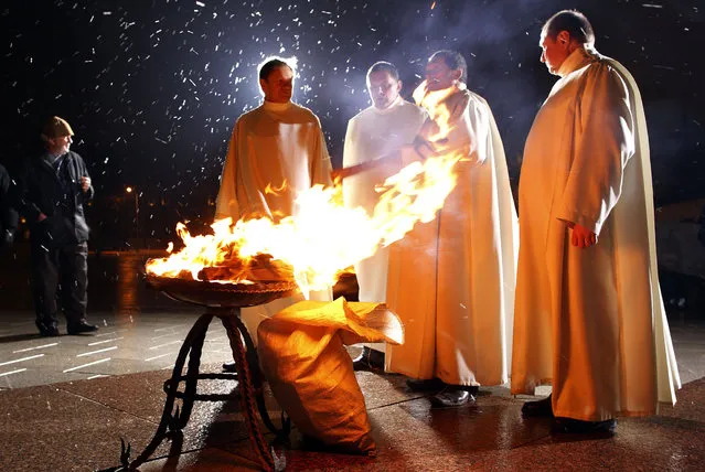 Priests to light the fire before the Easter vigil mass at the Cathedral in Vilnius, Lithuania, Saturday, March 30, 2013. (Photo by Mindaugas Kulbis/AP Photo)