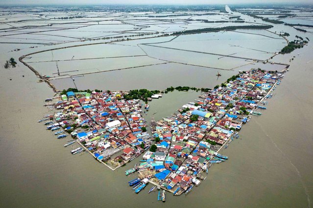 An aerial view taken with a drone shows Tibaguin Island partly submerged in seawater amid rising tides on August 9, 2025 in Hagonoy, Philippines. In the Philippines’ coastal communities, the water has been rising for years—a slow, relentless encroachment fueled by melting ice sheets in Antarctica, the sinking of land from decades of unchecked groundwater extraction, and the swelling seas of a warming planet. But residents say the sharpest surge came with large-scale reclamation and other man-made coastal developments, which have altered currents and forced the tide farther inland. Now, even the gentlest tide can unleash deep floods, drowning streets and homes in minutes, a daily reminder of how human activity can accelerate a disaster already set in motion by climate change. (Photo by Ezra Acayan/Getty Images)