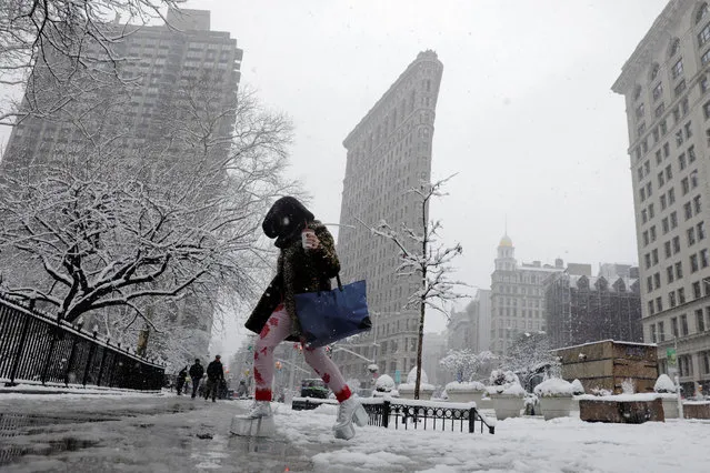A pedestrian wearing platform shoes crosses the street during a late season nor'easter in New York, U.S., March 21, 2018. (Photo by Lucas Jackson/Reuters)