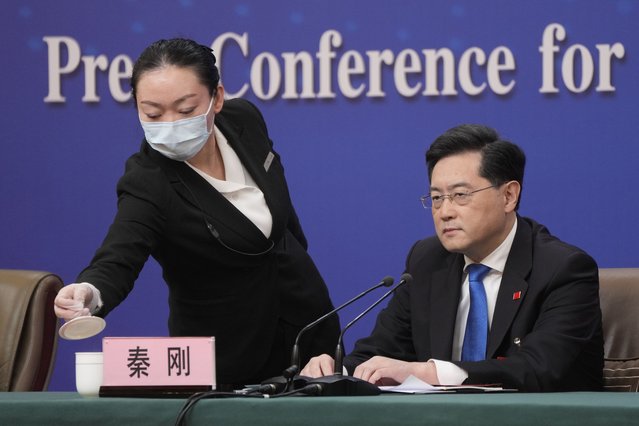 Chinese Foreign Minister Qin Gang looks on as a hostess refills his cup during a press conference held on the sidelines of the annual meeting of China's National People's Congress (NPC) in Beijing, Tuesday, March 7, 2023. (Photo by Mark Schiefelbein/AP Photo)