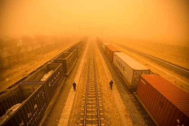 This photo taken on March 21, 2023 shows police officers checking train cars at a border checkpoint during a sandstorm in the border city of Erenhot, in China's northern Inner Mongolia region. (Photo by AFP Photo/China Stringer Network)