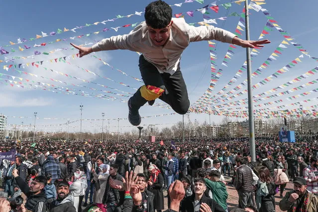 A Supporters of Pro-Kurdish Peoples' Democratic Party (HDP) gets thrown into the air by his friends as they shout slogans during a rally as part of Nowruz (Newroz), or Kurdish New Year, celebrations in Diyarbakir, Turkey, 21 March 2023. Newroz or Nowruz, which means “new day” in the Persian language, marks the arrival of spring and the first day in the Iranian calendar. It is widely celebrated in the Persian and neighboring regions and recognized on the UNESCO List of the Intangible Cultural Heritage of Humanity. (Photo by Sedat Suna/EPA)