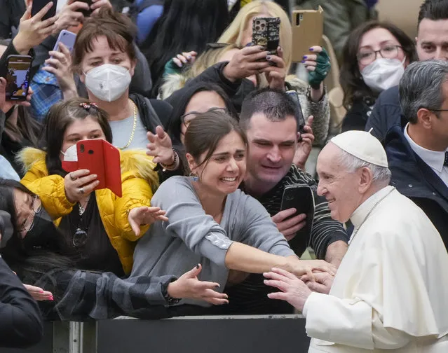 Pope Francis is greeted by faithful attending his weekly general audience in the Paul VI Hall at the Vatican, Wednesday, February 23, 2022. (Photo by Gregorio Borgia/AP Photo)