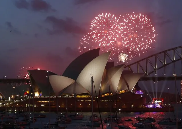 Fireworks light up the Sydney Opera House during an early light show before the new year December 31, 2014. More than 10,000 aerial fireworks, 25,000 shooting comets and 100,000 pyrotechnic effects are expected to be used during the annual Sydney Harbour New Year's Eve show, with an estimated 1.6 million people watching from along the harbour foreshore, local media reported. (Photo by Jason Reed/Reuters)