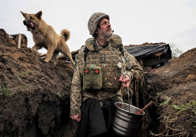 Military chaplain Yurii looks on in a trench after an Orthodox Easter service for Ukrainian servicemen at their position, as Russia's attack on Ukraine continues, in Kharkiv region, Ukraine on April 15, 2023. (Photo by Sofiia Gatilova/Reuters)