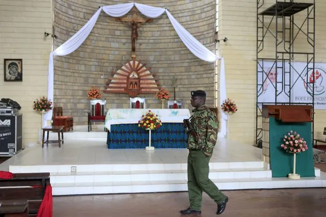 A policeman walks near the alter where Pope Francis will conduct a mass at the St. Joseph the Worker Catholic Parish in Kangemi slums in Kenya's capital Nairobi November 24, 2015. (Photo by Noor Khamis/Reuters)