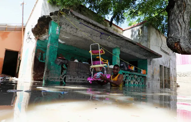 A resident evacuates furniture after rain water flooded his home in Mogadishu, Somalia on May 21, 2018 after homes were inundated in Somalia' s capital following heavy overnight rainfall. (Photo by Feisal Omar/Reuters)