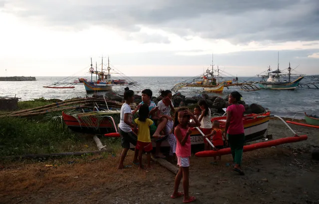 Residents gather near fishing boats that just returned from disputed Scarborough Shoal, as they are docked at the coastal village of Cato in Infanta, Pangasinan in the Philippines, October 31, 2016. (Photo by Erik De Castro/Reuters)