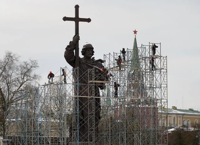 Municipal workers disassemble scaffolding around monument to Vladimir the Great, who brought Christianity to pagan Kievan Rus in the 10th century in downtown Moscow, Russia with the Kremlin at the background on Tuesday, November 1, 2016. The official opening ceremony will be held on Friday, when Russia celebrates the National Unity Day. (Photo by Ivan Sekretarev/AP Photo)