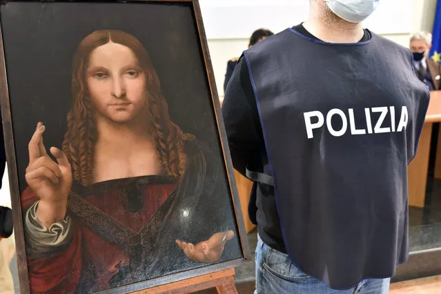 An Italian police officer stands by a copy of the “Salvator Mundi” (Savior of the World) by Leonardo da Vinci, in Naples, Italy, Wednesday, January 20, 2021. Italian police have recovered a copy of Leonardo da Vinci’s 16th century “Salvator Mundi” painting of Jesus Christ that was stolen from a Naples church without the priests even realizing it was gone. The discovery was made over the weekend when Naples police working on a bigger operation found the painting hidden in an apartment. Police chief Alfredo Fabbrocini said the owner offered a “less than credible” explanation that he had “casually” bought it at a small market. (Photo by Italian Police via AP Photo)