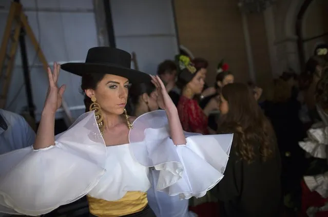 A model adjusts her hat backstage during the “We Love Flamenco” fashion show in the Andalusian capital of Seville January 14, 2015. (Photo by Marcelo del Pozo/Reuters)