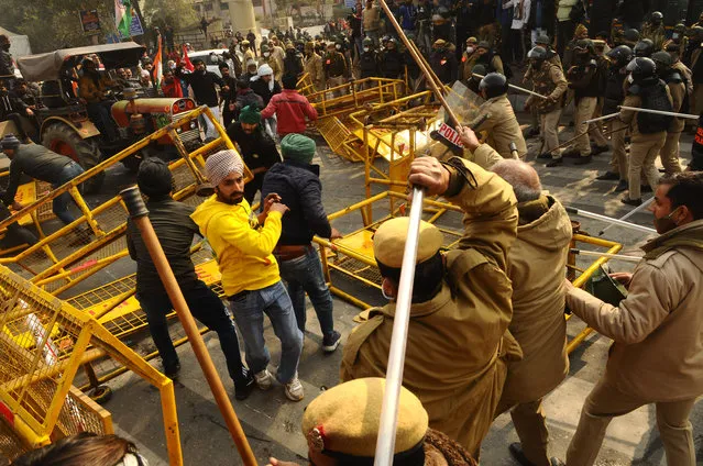 Delhi Police personnel lathicharge protesters in the farmers march to Delhi in protest against farm reform laws, in New Delhi on India January 26, 2021, The thousands of farmers drove a convoy of tractors into the Indian capital as the nation celebrated Republic Day on Tuesday in the backdrop of agricultural protests that have grown into a rebellion and rattled the government. (Photo by Imtiyaz Khan/Anadolu Agency via Getty Images)
