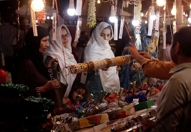 Women buy bangles and other jewellery at a stall ahead of Eid al-Fitr, which marks the end of the holy fasting month of Ramadan, in Islamabad, Pakistan June 13, 2018. (Photo by Faisal Mahmood/Reuters)