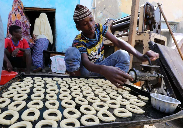 A Somali man prepares traditional cakes and biscuits inside a bakery ahead of the upcoming Eid al-Fitr holiday, marking the end of the Muslim holy month of Ramadan, in Mogadishu, Somalia June 13, 2018. (Photo by Feisal Omar/Reuters)