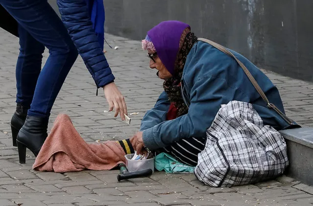 An elderly woman begs for money in central Chisinau, Moldova, November 12, 2016. (Photo by Gleb Garanich/Reuters)