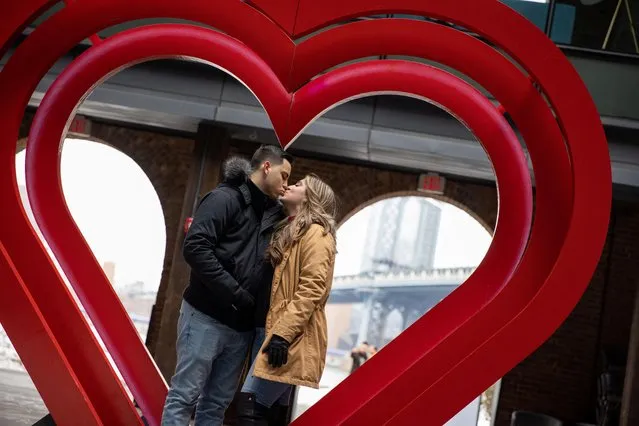 Angelina Sarge and Richard Rubido kiss in front of a heart sculpture in DUMBO on Valentine's Day during the coronavirus disease (COVID-19) pandemic, in the Brooklyn borough of New York City, New York, U.S., February 14, 2021. (Photo by Caitlin Ochs/Reuters)