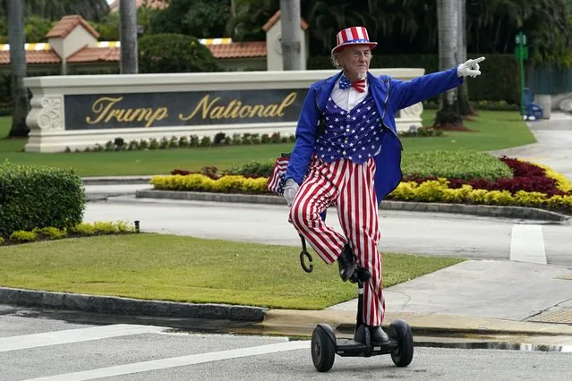 A man dressed as Uncle Sam waits at a stoplight outside Trump National Doral resort in Doral, Fla., Monday, June 12, 2023. (Photo by Gerald Herbert/AP Photo)