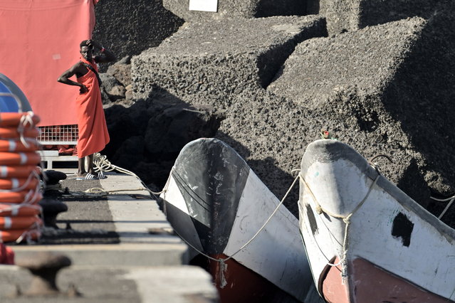 A migrant stands in front of canoes moored in the port of La Restinga, El Pinar municipality, El Hierro island, Canary Islands, Spain, 27 December 2024. More than 200 people travelling aboard several canoes were rescued early on 27 December by Spain's Maritime Rescue vessels off El Hierro island. (Photo by Gelmert Finol/EPA)