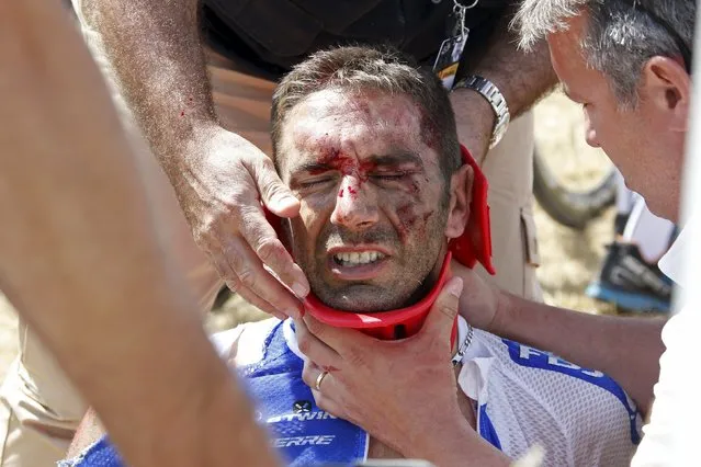 FDJ rider William Bonnet of France receives medical help as he sits on the ground after a fall during the 159.5km (99 miles) third stage of the 102nd Tour de France cycling race from Anvers to Huy, Belgium, July 6, 2015. (Photo by Eric Gaillard/Reuters)
