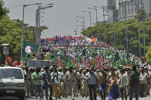Police personnel march in front of activists of pro-farmer organisations during a protest rally supporting the ongoing farmers' protest against the central government's recent agricultural reforms, in Bangalore on March 22, 2021. (Photo by Manjunath Kiran/AFP Photo)